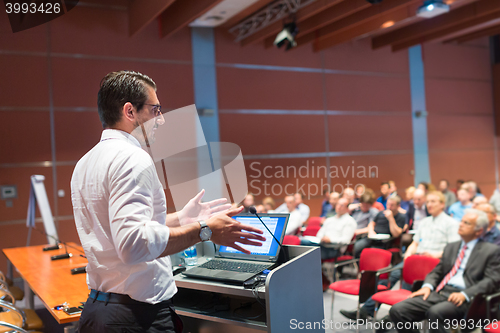 Image of Public speaker giving talk at Business Event.