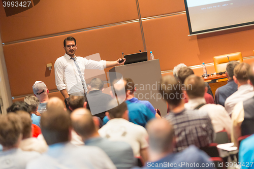 Image of Business speaker giving a talk in conference hall.