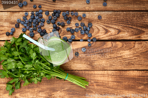 Image of Mug with green smoothie drink and bundle of fresh parsley