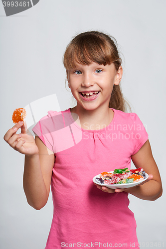 Image of Happy little girl holding a plate with colorful jelly candies