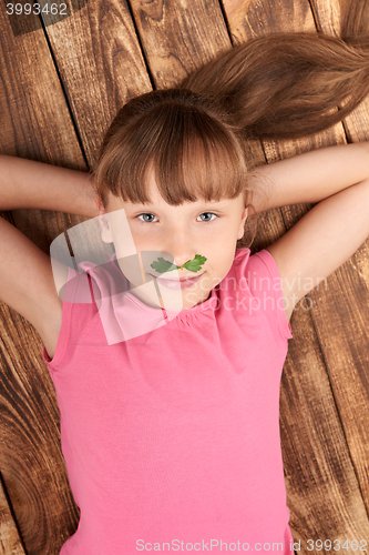 Image of Top view of a little girl lying on back