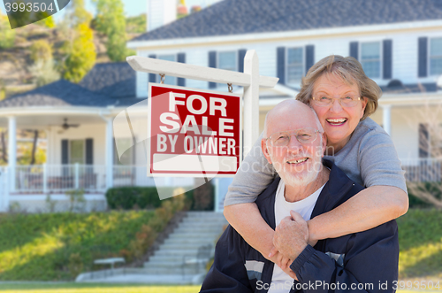 Image of Senior Adult Couple in Front of Real Estate Sign, House