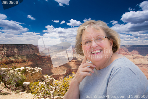 Image of Happy Senior Woman Posing on Edge of The Grand Canyon