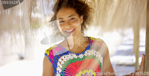 Image of Woman under thatch beach umbrella