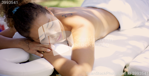 Image of Woman on massage table at outdoor spa