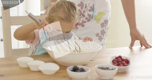 Image of Little girl baking with her mother