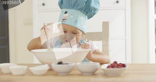 Image of Adorable smiling toddler at mixing bowl