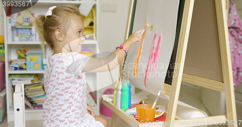 Image of Cute little blond girl painting with watercolors