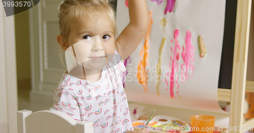 Image of Pretty confident little girl painting at home