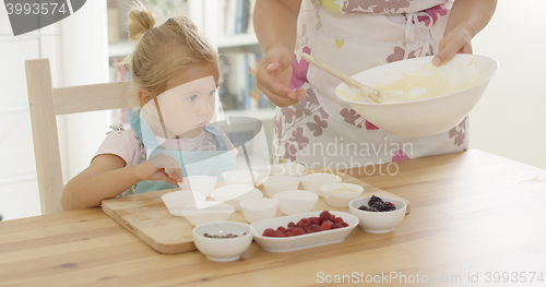 Image of Little girl assisting Mum with the baking