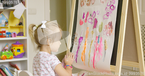 Image of Artistic little girl painting a creative design
