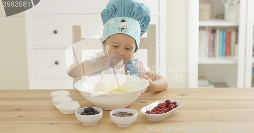 Image of Adorable smiling toddler at mixing bowl