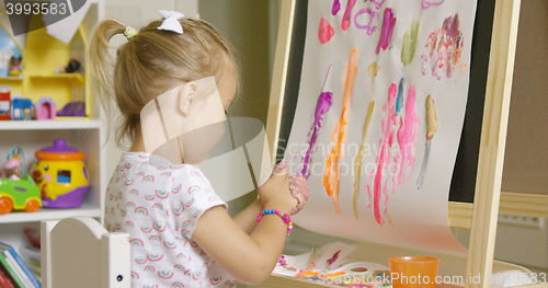 Image of Creative little girl painting an abstract picture