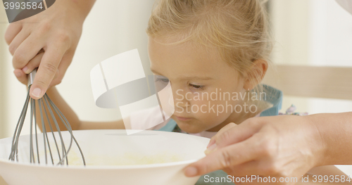 Image of Fascinated little girl learning to bake