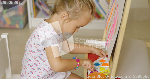 Image of Cute little girl mixing paints for her painting