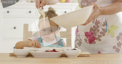 Image of Pouring muffin batter into holders