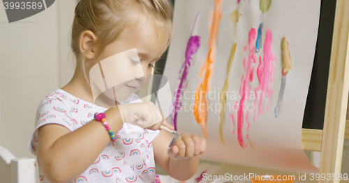 Image of Little girl applying paint to the back of her hand