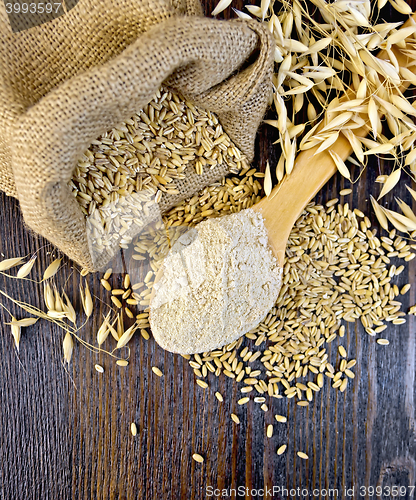 Image of Flour oat in wooden spoon with bag on board top