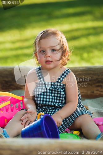 Image of The little baby girl playing toys in sand