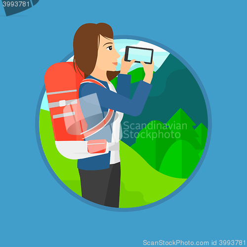 Image of Woman with backpack taking photo.