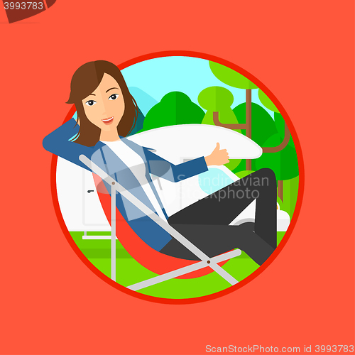 Image of Woman sitting in chair in front of camper van.