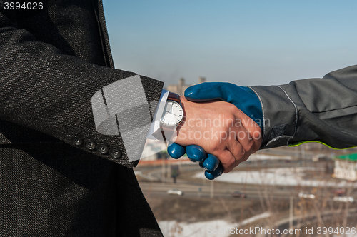 Image of worker shakes hands with businessman