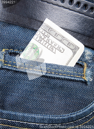 Image of Stack of dollar bills in jeans pocket