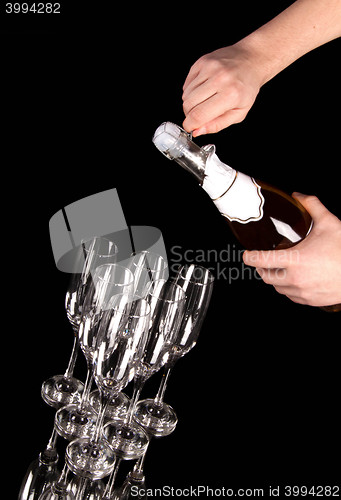 Image of man hands opening champagne bottle