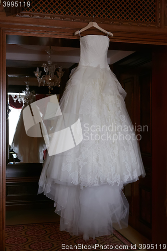 Image of White Wedding dress hanging on a shoulders
