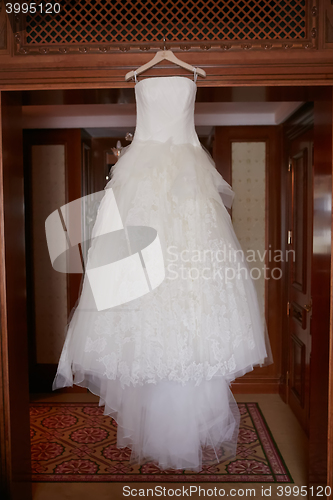 Image of White Wedding dress hanging on a shoulders