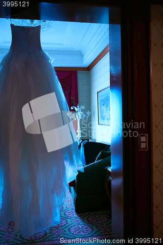 Image of White Wedding dress hanging on a shoulders