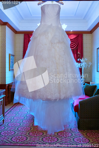 Image of White Wedding dress hanging on a shoulders
