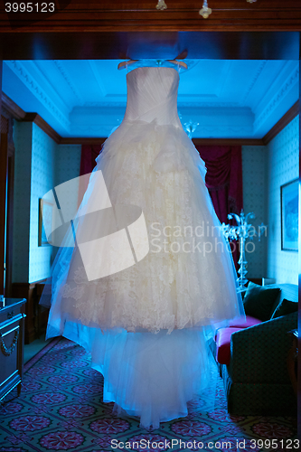 Image of White Wedding dress hanging on a shoulders