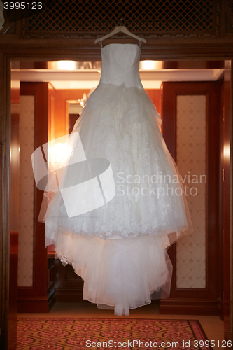 Image of White Wedding dress hanging on a shoulders