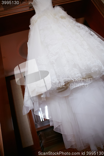 Image of White Wedding dress hanging on a shoulders