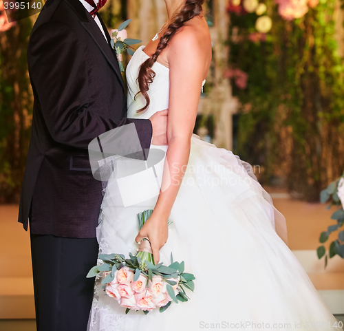 Image of Bride and groom holding hands close up no face