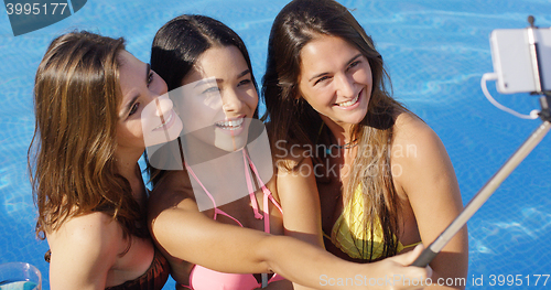Image of Three young women taking a selfie in the pool