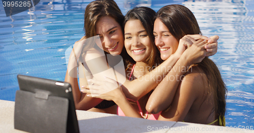 Image of Three young woman pose for a tablet selfie