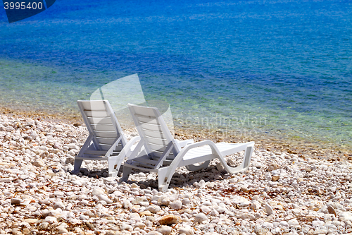 Image of Two deck chairs on beach in sunny autumn day
