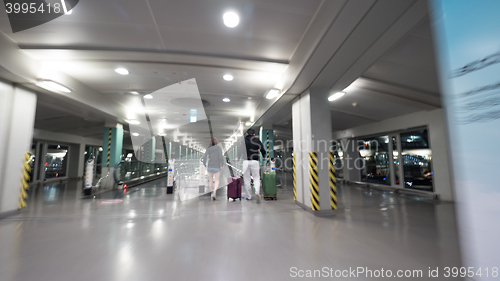 Image of Travelers with baggage walking to flat escalator at Seoul airport