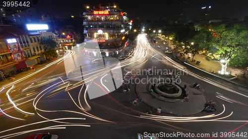Image of City square with traffic in motion at night. Hanoi, Vietnam