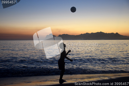 Image of Playing soccer on the beach sunset