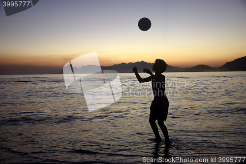 Image of Playing soccer on the beach sunset
