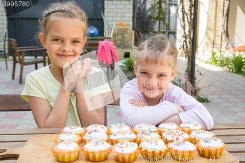 Image of Two girls rejoice freshly baked Easter cupcakes