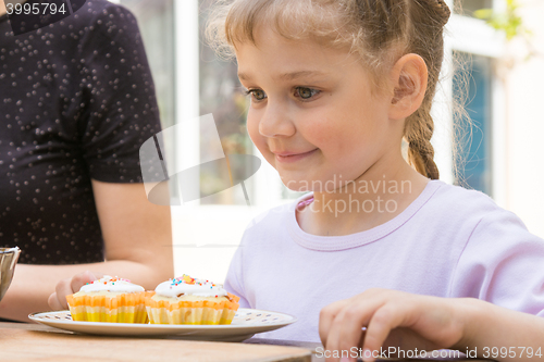 Image of Happy girl is preparing to eat Easter cupcakes