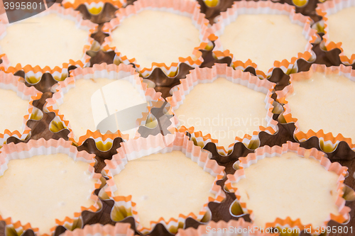 Image of Many raw cakes in tins, ready for roasting