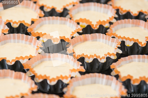 Image of Preparations for baking cakes in molds on a baking sheet