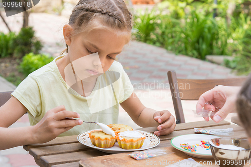 Image of The girl carefully coated with confectionery glaze Easter cupcakes