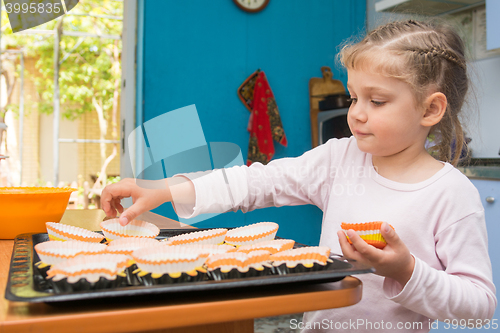 Image of The child lays on a baking tins Easter cupcakes