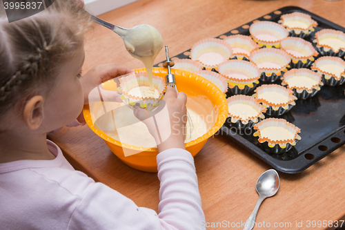 Image of Daughter holds the mold for the cake, while my mother draws the dough from the bowl